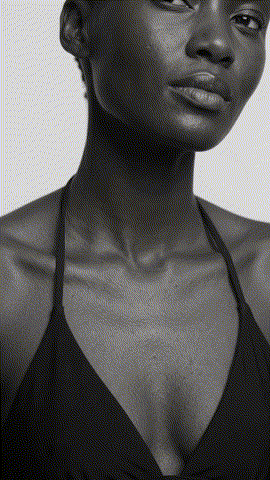 Femme à la peau foncée tenant un flacon MELA SKIN